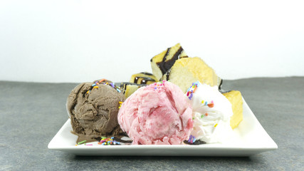 Honey toast with ice cream strawberry and chocolate topped whip cream in plate on a black stone floor table, Front view with copy space for your text..
