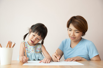 Obraz na płótnie Canvas Happy Asian Mother and daughter drawing together.