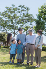 公園で微笑む三世代家族
