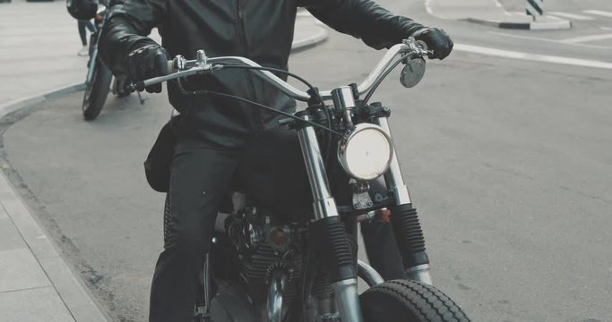 Motorbike handle grips. Close up the hand of the motorcyclist holds the trottle and pushes the brake lever. The biker inserts the key into the ignition lock and turns the bike.