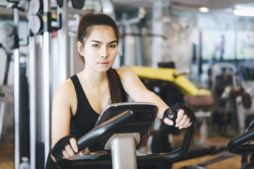 Attractive woman riding on the spinning bike and looking at camera.