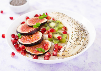 Delicious and healthy oatmeal with figs, kiwi, pomegranate, banana and chia seeds. Healthy breakfast. Fitness food. Proper nutrition.