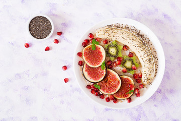 Delicious and healthy oatmeal with figs, kiwi, pomegranate, banana and chia seeds. Healthy breakfast. Fitness food. Proper nutrition. Flat lay. Top view.