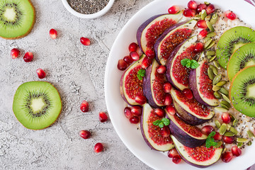 Delicious and healthy oatmeal with figs, kiwi and pomegranate. Healthy breakfast. Fitness food....