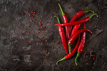  Red hot chili peppers op grijze tafel. Bovenaanzicht © timolina