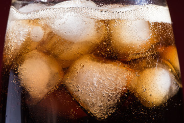 Cola with ice cubes in a close-up glass