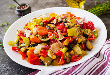 Baked vegetables on white plate. Eggplant, zucchini, tomatoes, paprika and onions