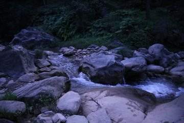 Stream of fresh water flowing between rocks 