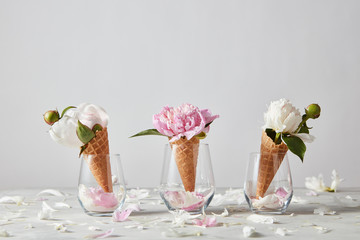 Decorative post card of delicate pink and white peony flowers in a wafer cones in a glass with...
