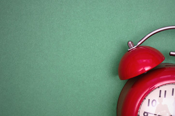 Red alarm clock face isolated on green background.