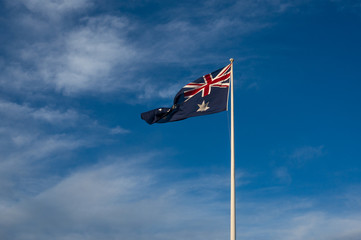 Australian national flag against blue sky on the background