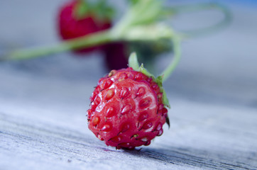 Ripe forest strawberries on rough wooden surface