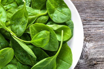 Fresh organic spinach on plate, leafy green vegetables, healthy food concept