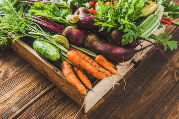 Fresh vegetable, organic produce on farmer market. Vegetables in the box on wooden table. - obrazy, fototapety, plakaty