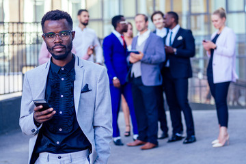 multinational and multiethnic corporate business people boss and colleagues partners standing and smiling on on the street background skyscraper windows