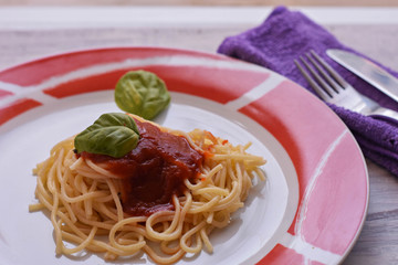 Delicious homemade spaghetti pasta  whit tomato sauce served at plate at light wooden background