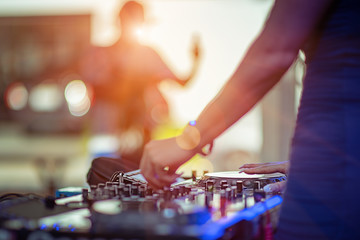 DJ takes control platter spindle of rhythm music with and mixer dash board, playing the song at the party, adjusting the music with the controller, fun of music and light colors, Music & Event party