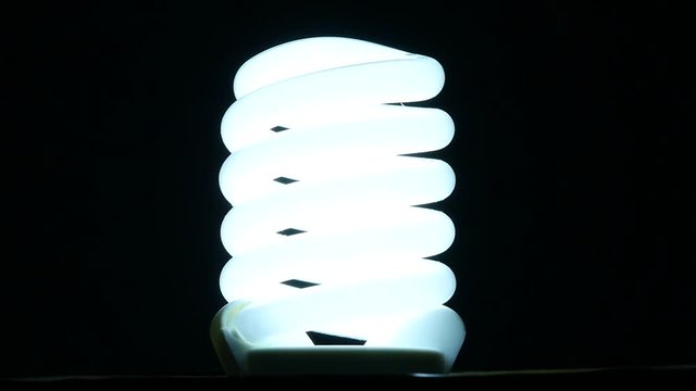 fluorescent lamp turning on and off on black background, slow motion