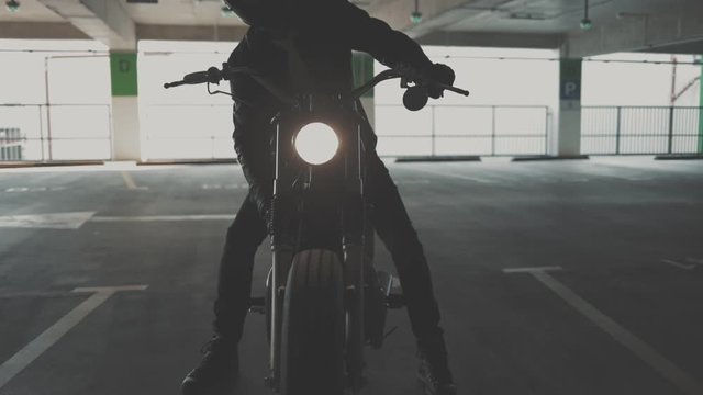 Close up of hand of the motorcyclist inserting the key into the ignition lock and starting the engine of the bike. Urban lifestyle scene. Slow motion video shooting by handheld gimbal