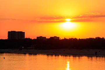 Fototapeta premium Orange sunset over a river Dnieper in Kremenchug city, Ukraine