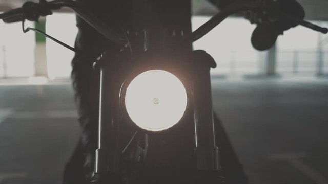 Close up of hand of the motorcyclist inserting the key into the ignition lock and starting the engine of the bike. Urban lifestyle scene. Slow motion video shooting by handheld gimbal