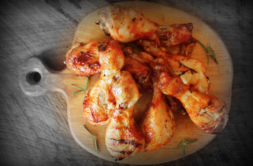 Grilled chicken legs on cutting board.Rustic dinner background . Top view