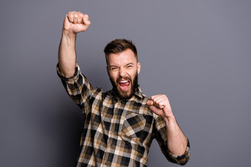 Close up portrait of young man raised his fists rejoicing at the