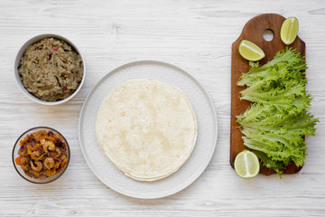 Shrimp taco ingredients on white wooden background, top view. Flat lay, overhead, from above.