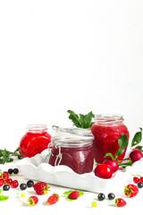 homemade jam in a glass jar of various berries and plums on a light background.Healthy food, diet, detox, clean eating and vegetarian concept with copy space.