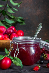 homemade jam in a glass jar of various berries and plums on a dark  background.Healthy food, diet, detox, clean eating and vegetarian concept with copy space.