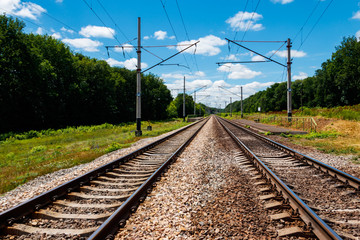 Scenic railroad in rural area and blue sky with white clouds in summer