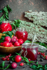homemade jam in a glass jar of various berries and plums on a dark  background.Healthy food, diet, detox, clean eating and vegetarian concept with copy space.