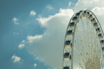 Vintage White big Ferris wheel  with blue sky sharp clouds