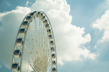 Vintage White big Ferris wheel  with blue sky sharp clouds