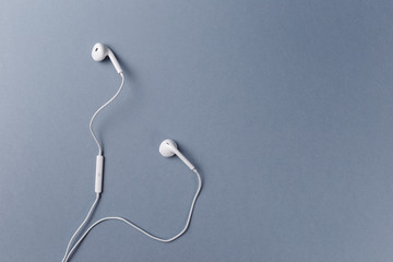 White headphones on a grey background. Top view. Flat lay. Copy space. Trendy colorful photo....