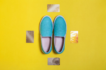 stylish women aquamarine slip on shoes surrounded by four golden credit cards on the yellow surface. view from the top. spring summer hipster trend. mockup for instagram