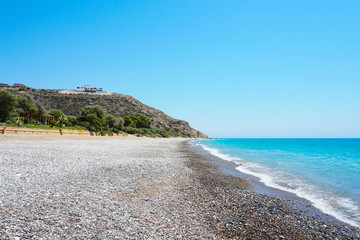 Empty pebble beach on the Mediterranean coast in Cyprus in sunny summer day