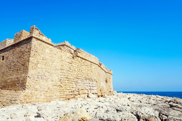 Fototapeta na wymiar Medieval Knight Castle on the Mediterranean coast in sunny summer day