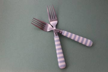 two forks with blue and white handles 