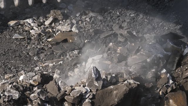 Excavator digging ore close-up. Bucket excavator rakes rock. Open pit mining.
