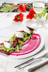 Healthy italian salad with beetroot, lettuce leaves and cheese feta and dressing with oil and mustard seeds.