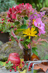 beautiful and colorful bouquet of flowers with red apples and leaf in a garden 