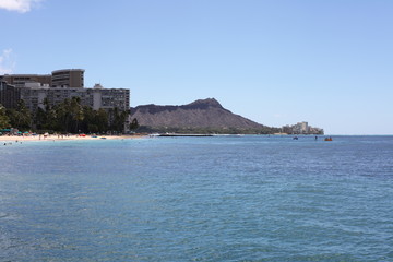 Fototapeta na wymiar Blue water coast with a mountain in the city ashore