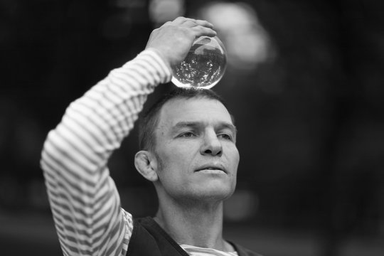 Transparent magic ball with reflection in the hands of a clown