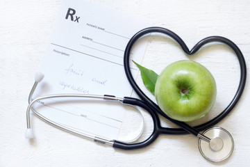 Alternative medicine healthy  sign concept with stethoscope heart and green apple on white...
