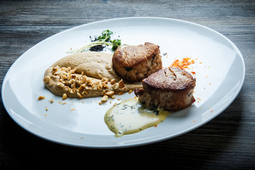 two tasty pieces of grilled meat with puree and sauce