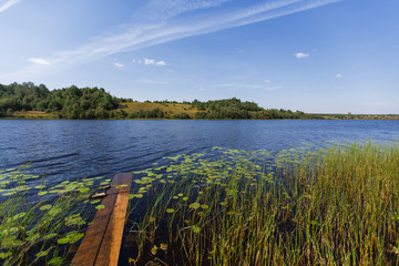 Shore of the lake with wooden boards in the village.