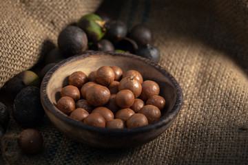 Macadamia nuts on sackcloth in dark light