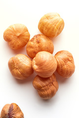 Pile of hazelnuts placed in a the middle on white background lighted with sun. Creative concept of health and wellness. Nuts. Selective focus