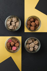 Set of handmade chocolate truffles in cocoa powder in a glass jar on black background